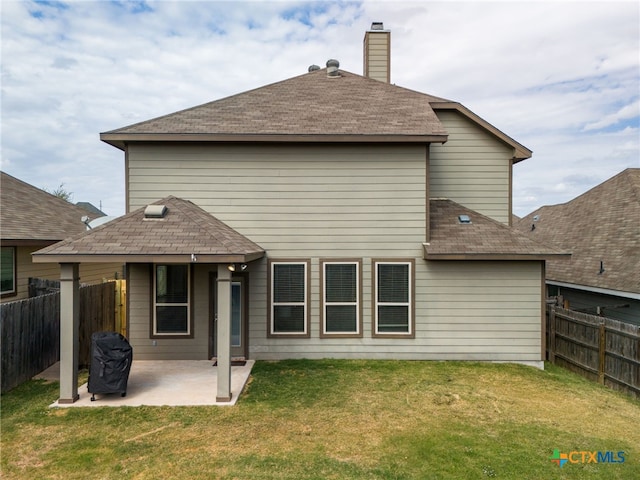 back of property with a lawn and a patio area