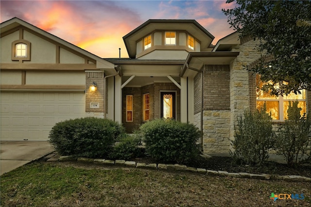 view of front of house with an attached garage, stone siding, and concrete driveway