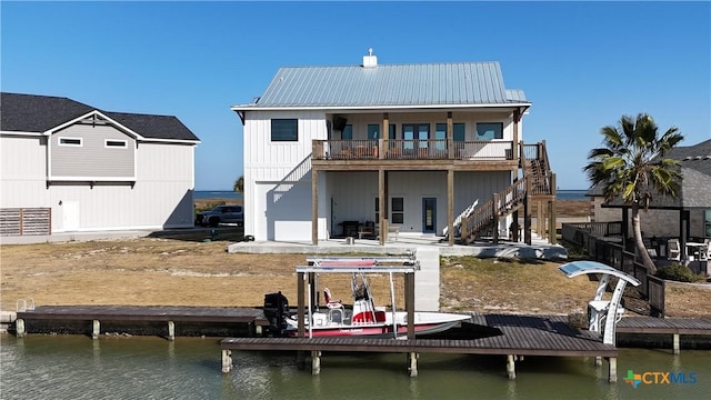 rear view of house featuring a balcony and a water view