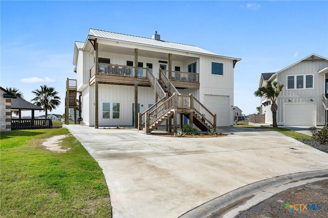 view of front facade with driveway, an attached garage, stairs, and metal roof