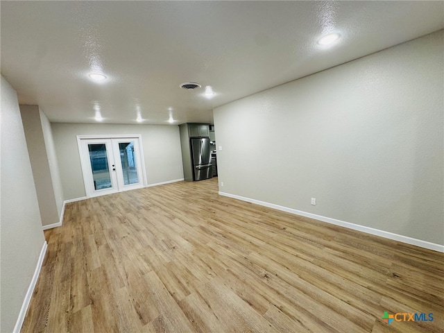 spare room with light wood-style flooring, visible vents, baseboards, and french doors