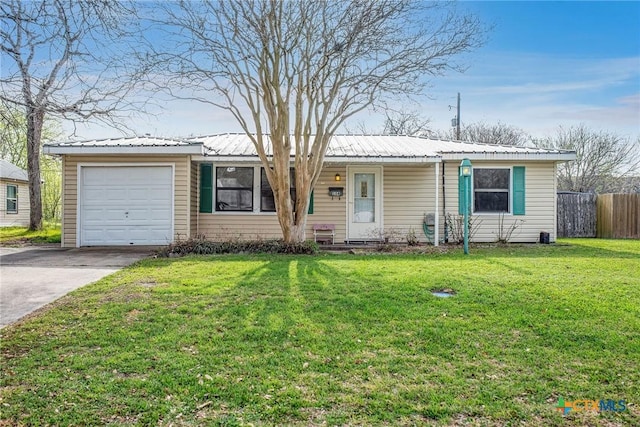 ranch-style home with a front lawn, fence, driveway, and metal roof