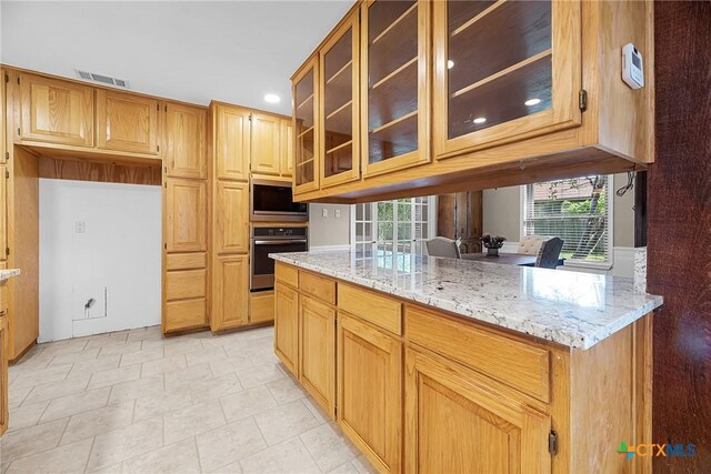 221 W Tanglewood Dr, New Braunfels, TX 78130 - kitchen with appliances with stainless steel finishes, light stone counters, glass insert cabinets, and recessed lighting