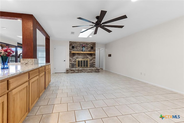221 W Tanglewood Dr, New Braunfels, TX 78130 - unfurnished living room featuring ceiling fan, a skylight, vaulted ceiling, a fireplace, and recessed lighting