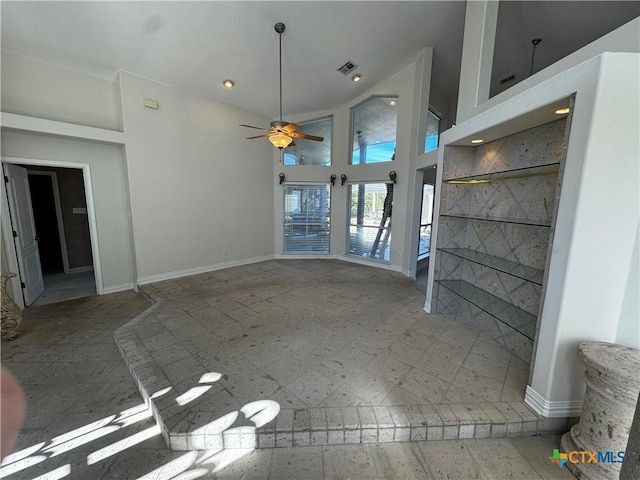 unfurnished living room with ceiling fan and a towering ceiling