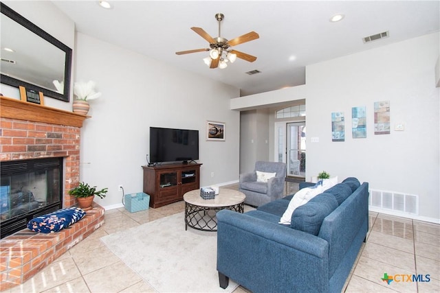 living room featuring ceiling fan, light tile patterned flooring, and a brick fireplace