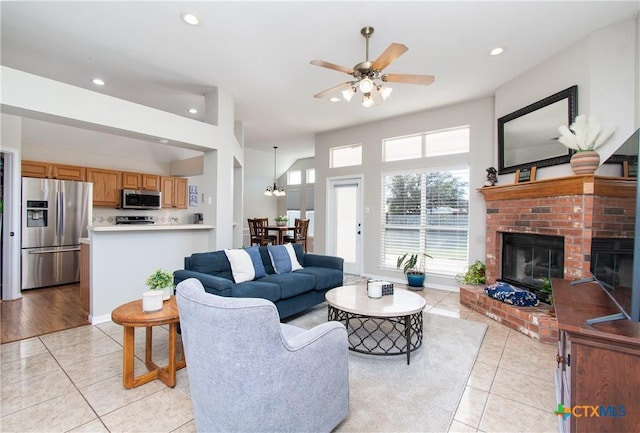 living room with a fireplace, light tile patterned floors, and ceiling fan