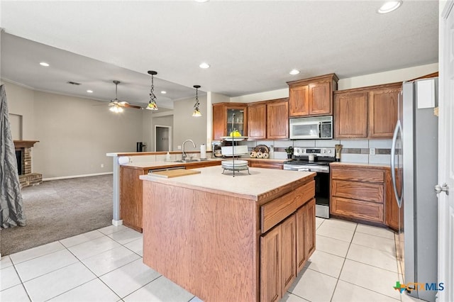3197 Robin Ln, Kempner, TX 76539 - kitchen with appliances with stainless steel finishes, brown cabinetry, recessed lighting, a peninsula, and light carpet