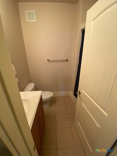 bathroom with vanity, toilet, and tile patterned floors