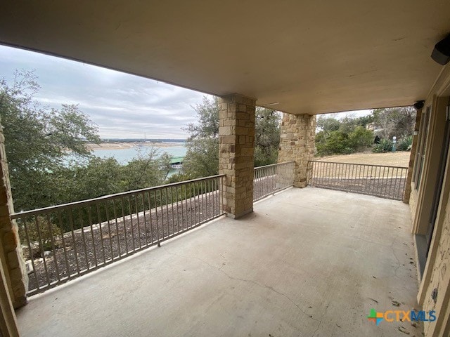 view of patio / terrace featuring a water view and a balcony