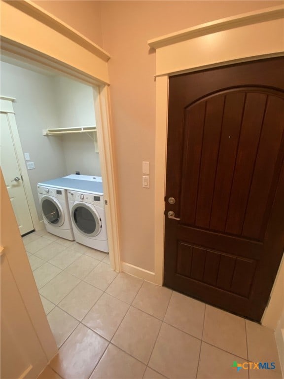 washroom with separate washer and dryer and light tile patterned floors