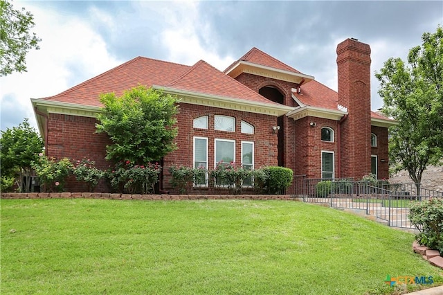 2110 Lakeview Loop, Killeen, TX 76543 - view of front of house with fence, a chimney, a front yard, and brick siding