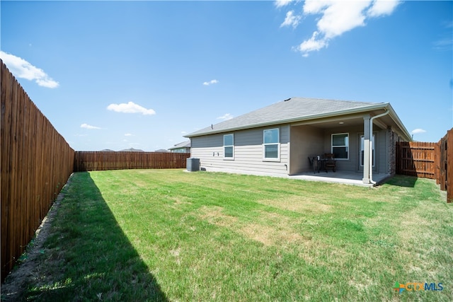 back of house with a yard, central AC, and a patio