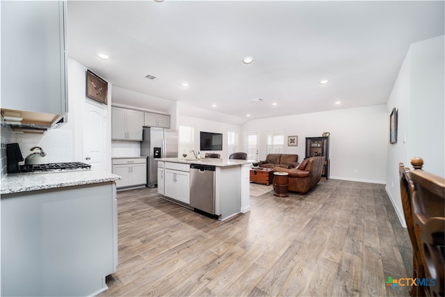 kitchen with a kitchen island with sink, appliances with stainless steel finishes, and light hardwood / wood-style flooring