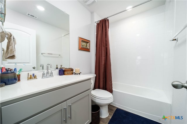 full bathroom with hardwood / wood-style floors, vanity, shower / bath combination with curtain, and toilet