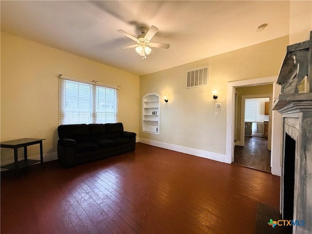 living room with ceiling fan and dark hardwood / wood-style flooring