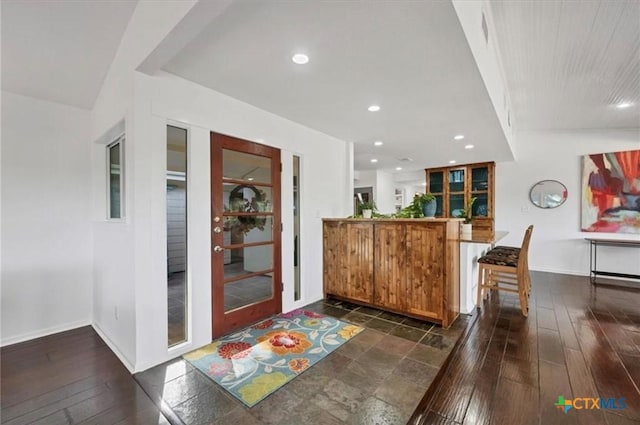 bar featuring baseboards, dark wood-type flooring, and recessed lighting