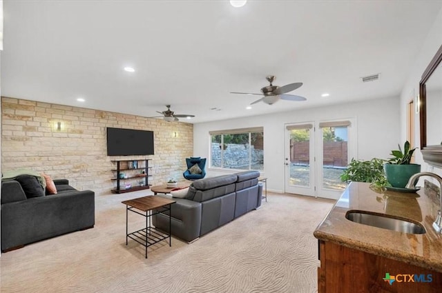 living area with a ceiling fan, visible vents, recessed lighting, and light colored carpet