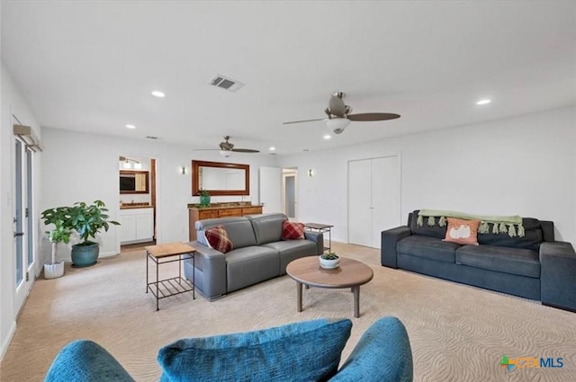 living room with ceiling fan and light colored carpet