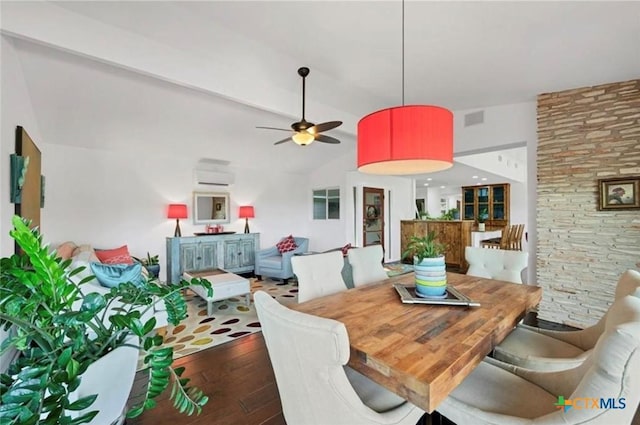 dining area featuring vaulted ceiling, hardwood / wood-style floors, ceiling fan, visible vents, and a wall unit AC