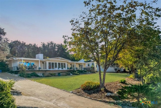 view of front of house featuring a front lawn and a chimney