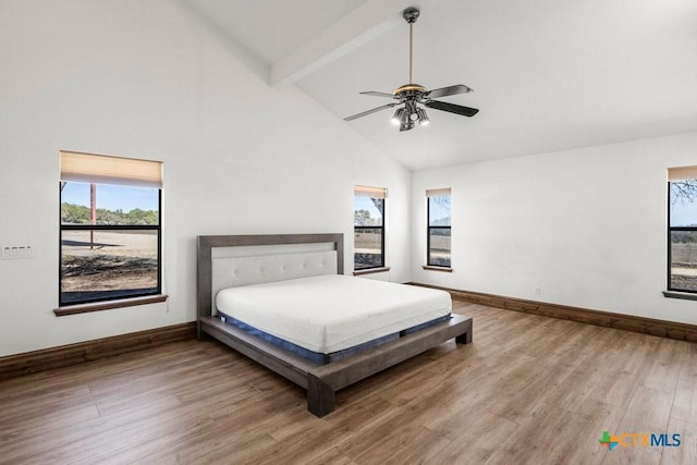 bedroom with beam ceiling, a ceiling fan, wood finished floors, high vaulted ceiling, and baseboards