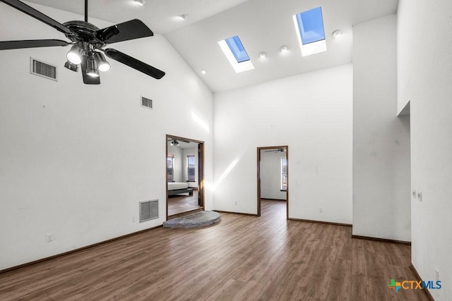 unfurnished room with wood finished floors, visible vents, and a ceiling fan