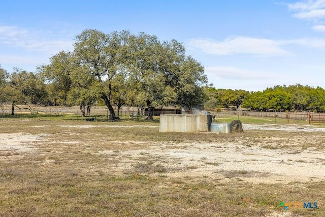 view of property's community featuring a rural view and fence