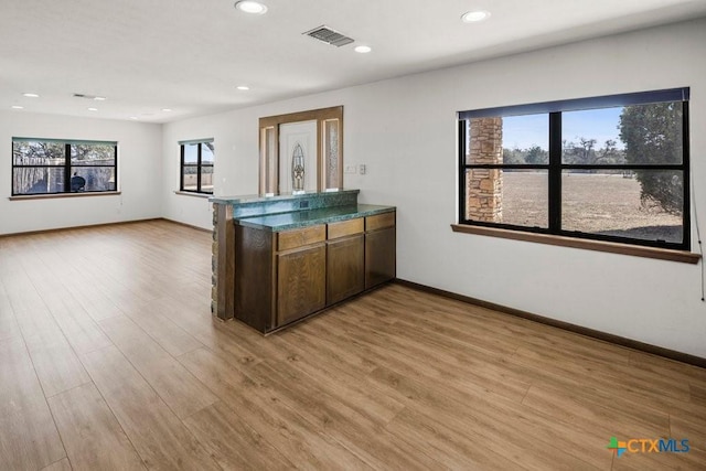 kitchen with baseboards, visible vents, a peninsula, light wood-style floors, and recessed lighting