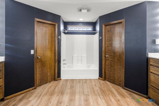 bathroom featuring shower / bath combination, wood finished floors, vanity, and baseboards