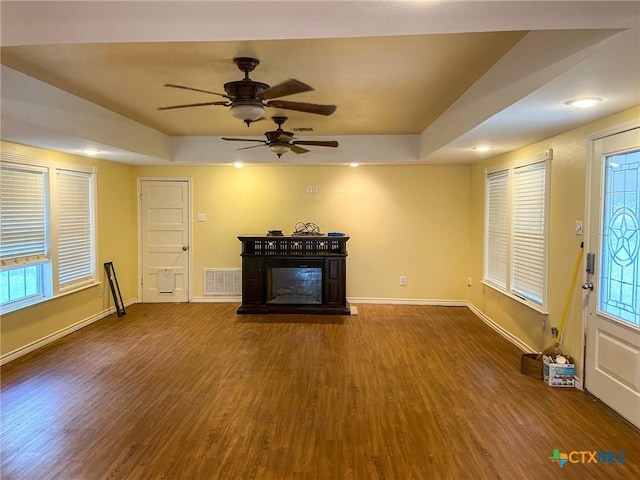 3514 Old Goliad Rd, Victoria, TX 77905 - unfurnished living room featuring wood finished floors, baseboards, a glass covered fireplace, a ceiling fan, and a tray ceiling