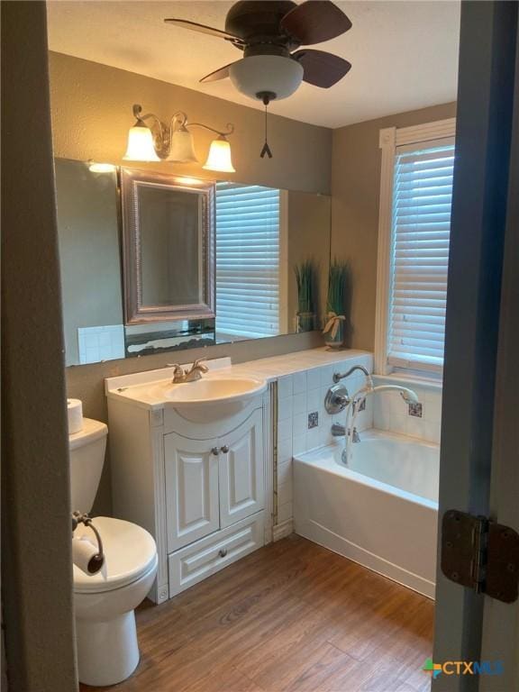 3514 Old Goliad Rd, Victoria, TX 77905 - bathroom with a bath, wood finished floors, vanity, toilet, and a ceiling fan