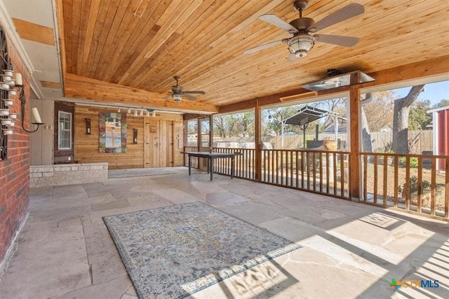 unfurnished sunroom with ceiling fan and wooden ceiling