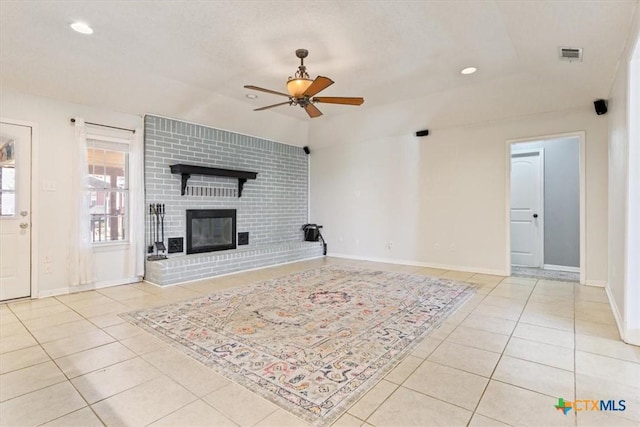 tiled living room featuring ceiling fan and a brick fireplace