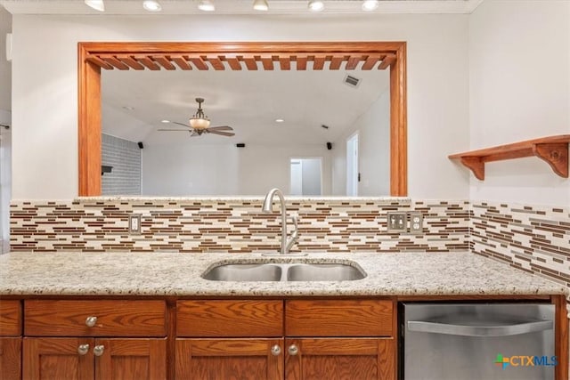 kitchen with light stone countertops, sink, ceiling fan, stainless steel dishwasher, and decorative backsplash