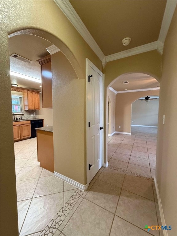 corridor with arched walkways, ornamental molding, light tile patterned flooring, and visible vents