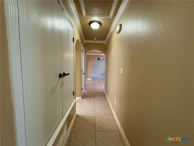 corridor featuring light tile patterned flooring and ornamental molding