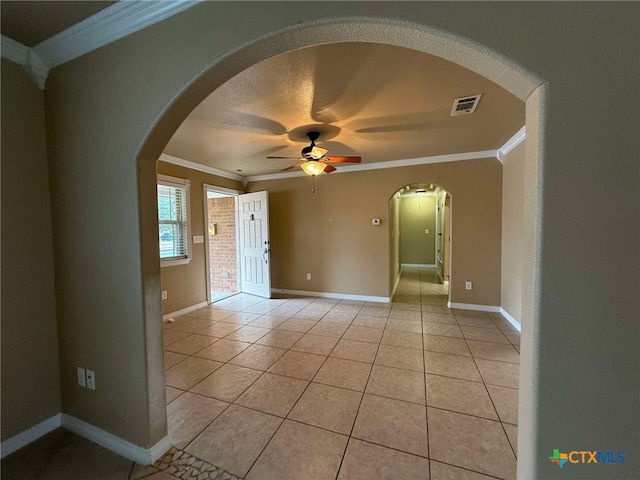 spare room with light tile patterned flooring, ceiling fan, crown molding, and a textured ceiling