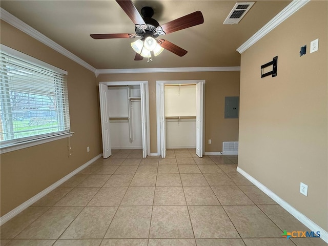 unfurnished bedroom with multiple closets, visible vents, crown molding, and light tile patterned floors