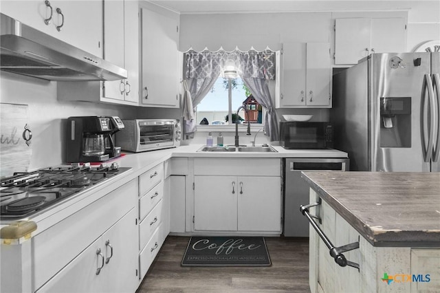 4811 Lilac Ln, Victoria, TX 77904 - kitchen featuring appliances with stainless steel finishes, a sink, under cabinet range hood, dark wood-style floors, and white cabinets