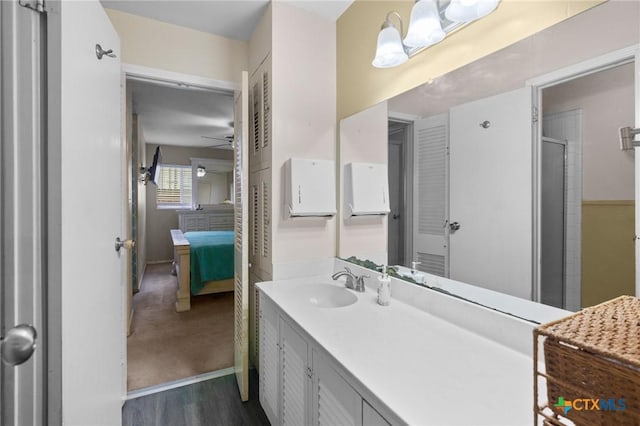4811 Lilac Ln, Victoria, TX 77904 - bathroom featuring ceiling fan, wood finished floors, vanity, an enclosed shower, and ensuite bathroom