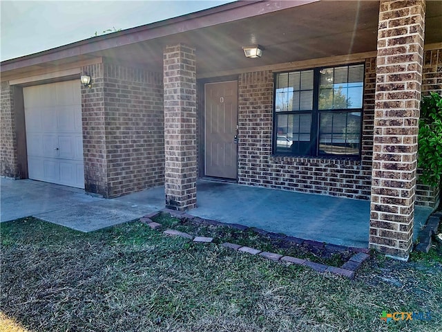 view of exterior entry featuring covered porch and a garage