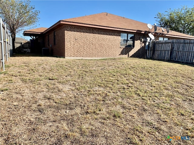 exterior space with a lawn and central AC unit