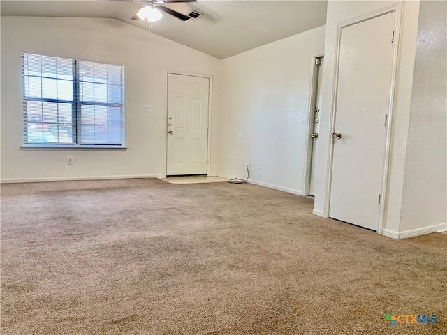 carpeted spare room featuring ceiling fan and vaulted ceiling