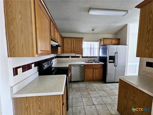 kitchen featuring appliances with stainless steel finishes, tasteful backsplash, light tile patterned floors, and sink