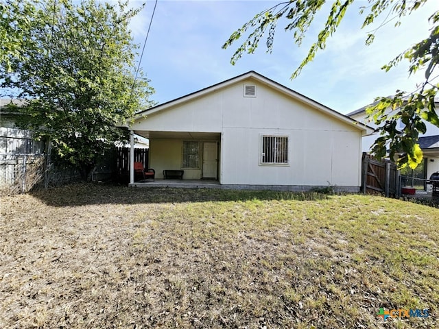 back of house featuring a patio and a lawn