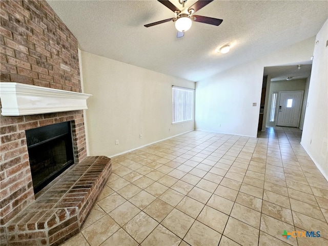 unfurnished living room featuring light tile patterned floors, a textured ceiling, a brick fireplace, and ceiling fan