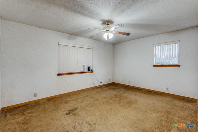 carpeted spare room with ceiling fan and a textured ceiling