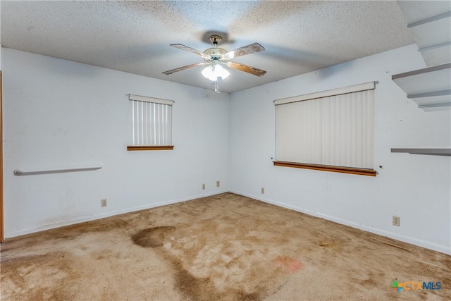 carpeted empty room featuring a textured ceiling and ceiling fan