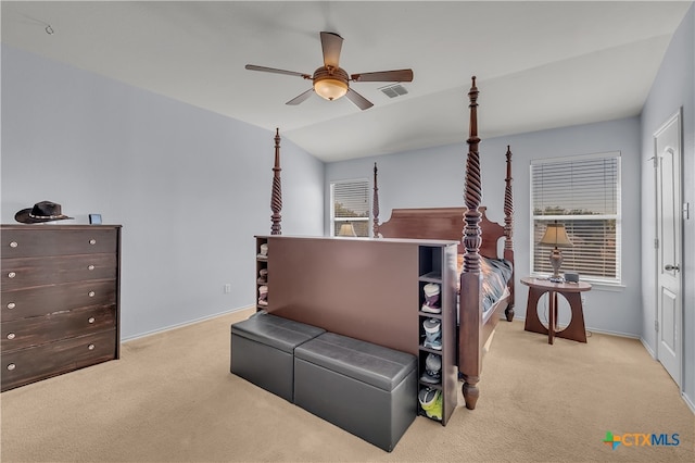 bedroom with ceiling fan, multiple windows, light carpet, and vaulted ceiling